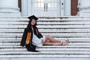 Jeesoo Kim poses in graduation garb on the Gilman Hall steps.