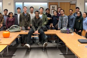 Anand Malpani poses with students in a Gilman Hall classroom.