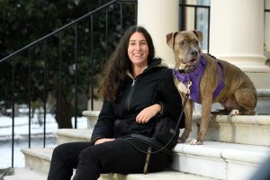 Rachel Sherman poses with her dog on a leash on marble steps.