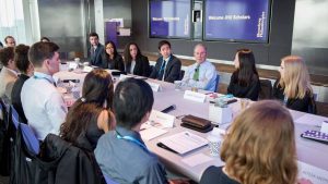 People sit around a long table having a business meeting.