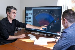 Brice Ménard and Nikita Shtarkman sit at a desk examining the map of the observable universe.