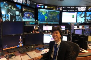 Daniel Chong poses in NASA's Mission Control Center.
