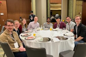 JHU researchers sitting around a table at the RECOMB gala dinner.