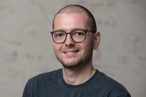 Headshot of Mathias Unberath wearing a gray T-shirt in front of a whiteboard.