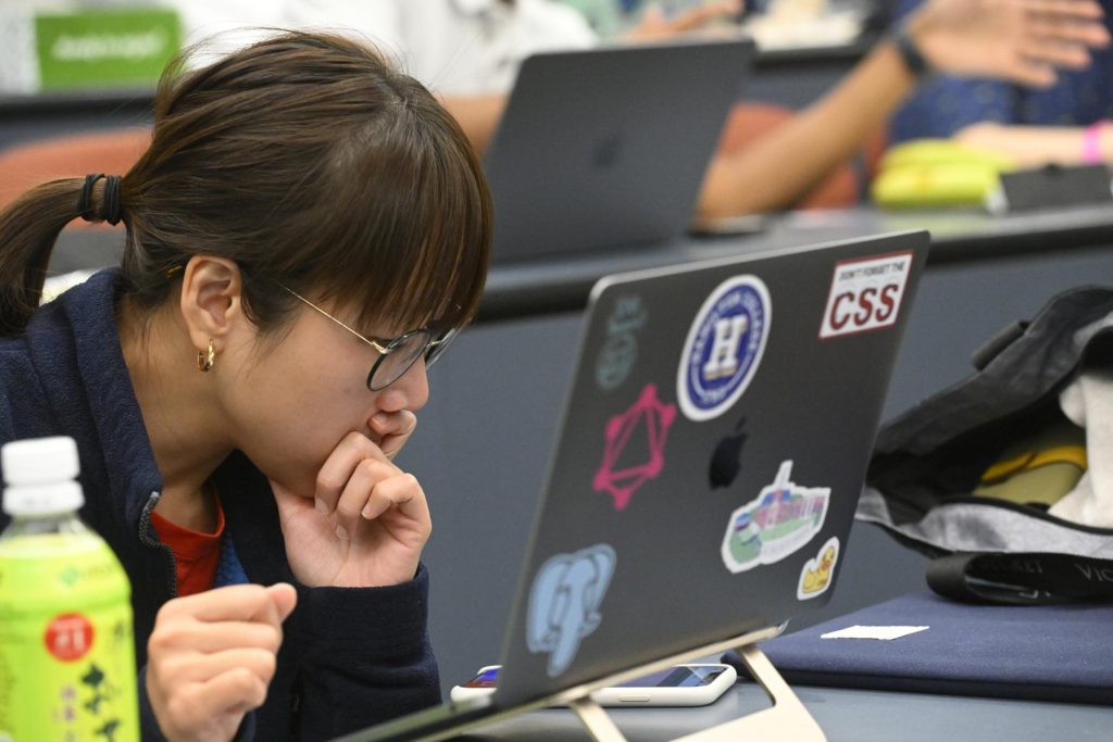 A student stares intently at her laptop.