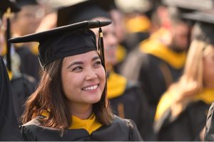 A master's graduate smiling, wearing a graduation cap.