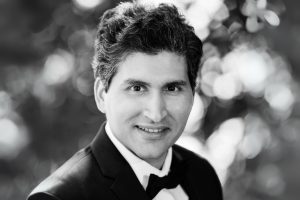 Grayscale headshot of Ali Madooei in formal dress.