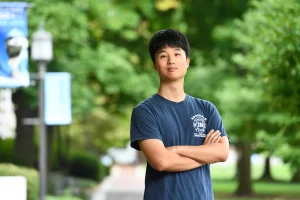 Jooyoung Ryu poses with his arms crossed on the Homewood campus.