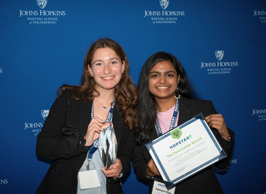Jamie Stelnik and Subhasri Vijay pose with a trophy and a certificate.