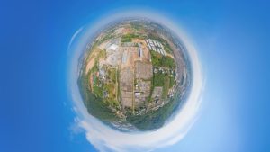 Illustration of the Earth in a bright blue sky, with images of man-made construction on the surface.