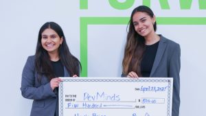 Anvii Mishra and Anika Mistry pose with a giant check.