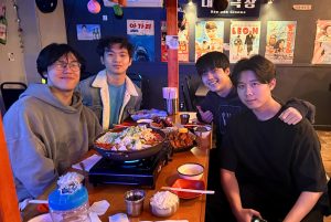 Alan Li, Johnny He, Ethan Lee, and Jonathan He sit around a Korean hotpot table.