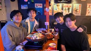 Alan Li, Johnny He, Ethan Lee, and Jonathan He sit around a Korean hotpot table.