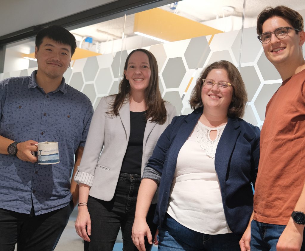 A group shot of Bohan Ni holding a coffee cup, Alexis Battle, Rebecca Keener, and Graydon Moorhead.