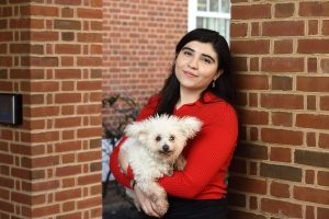 Alessa Carbo holds her small white dog, Frida.