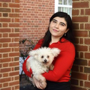 Alessa Carbo holds her small white dog, Frida.