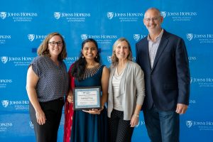 Sara Miner More, Subhasri Vijay, Joanne Selinski, and Randal Burns pose together. Vijay holds her award.