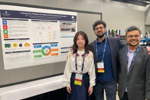 Kaixin Du, Ramit Saraswat, and Dibyajyoti Nath stand next to a poster titled “A Hands-On Platform for Medical Device Security Education”.