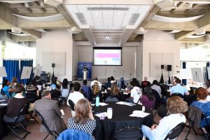 Attendees listen to a speaker in the Glass Pavilion.