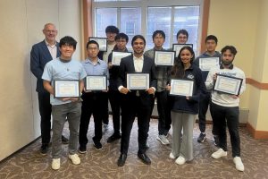 Randal Burns poses with the 2026 department awardees, who hold their framed award certificates.