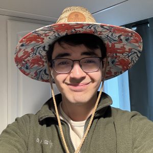 Selfie of Arda Uzunoğlu in a patterned beach hat.