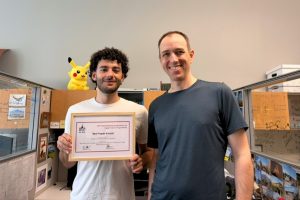 Nathaniel K. Brown and Ben Langmead pose in an office with their framed Best Paper Award.
